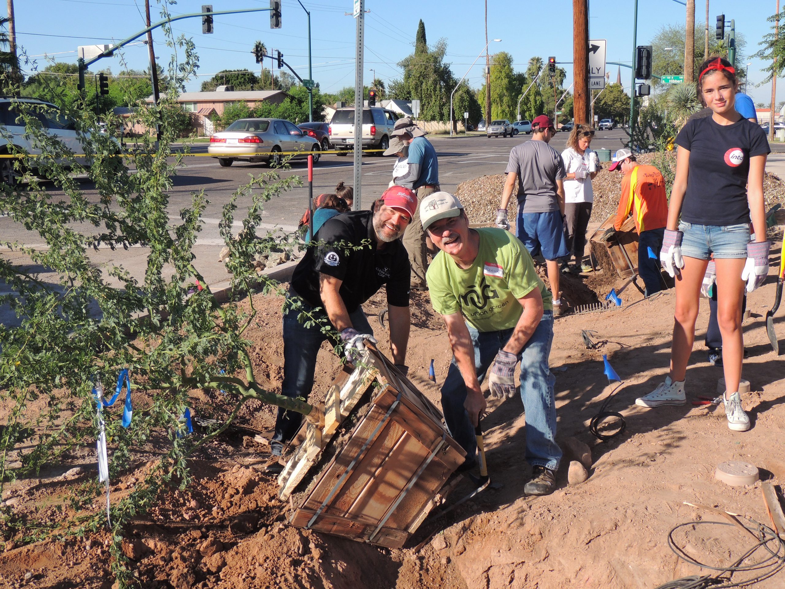 Steve Lopez, founder of Clean Air Cab, gets help planting a tree from volunteer Steve Priebe.