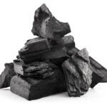 A pile of coal sits in front of a white background.