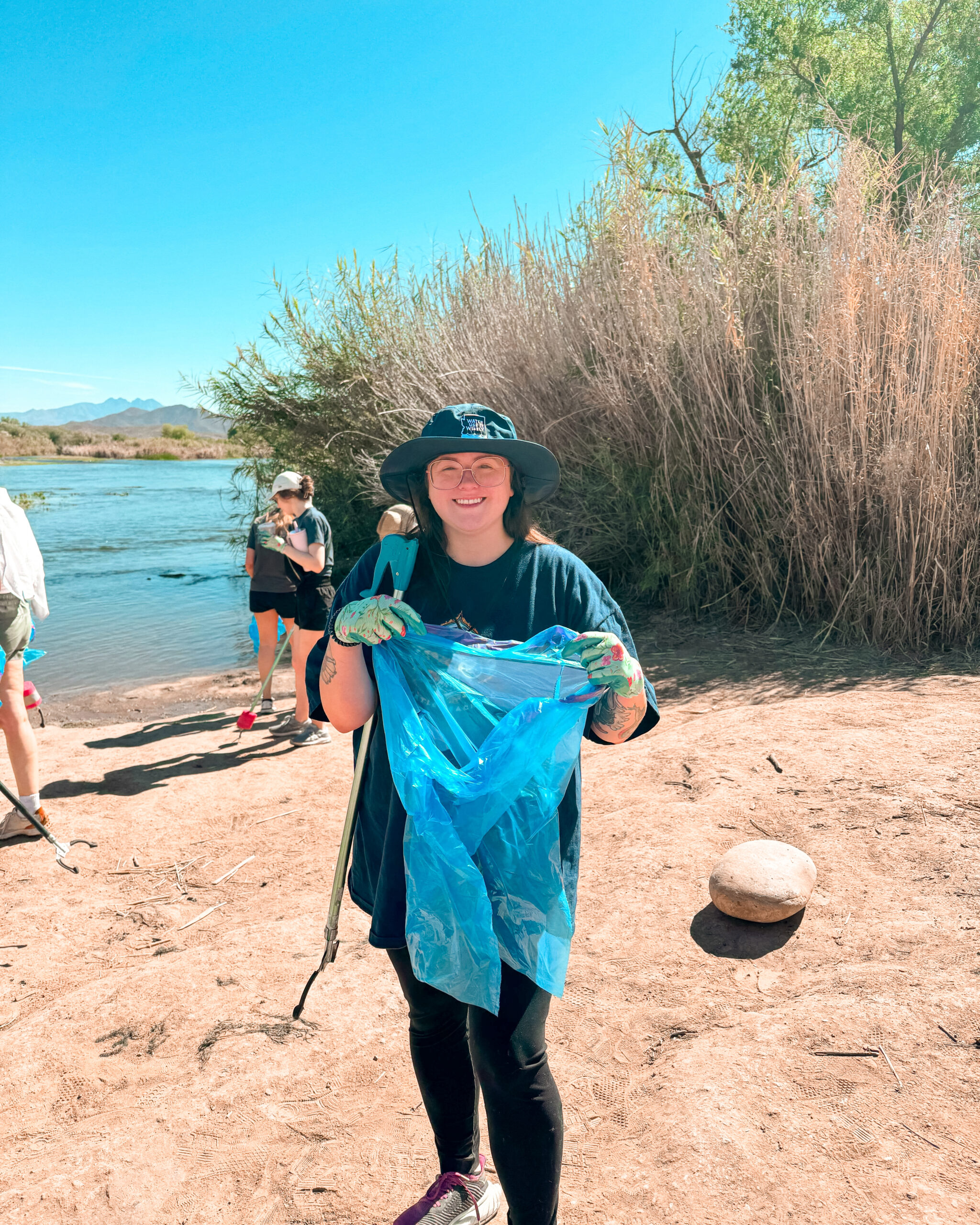 Lauren of HAPI works along the riverbank picking up litter during cleanup efforts at the Salt River