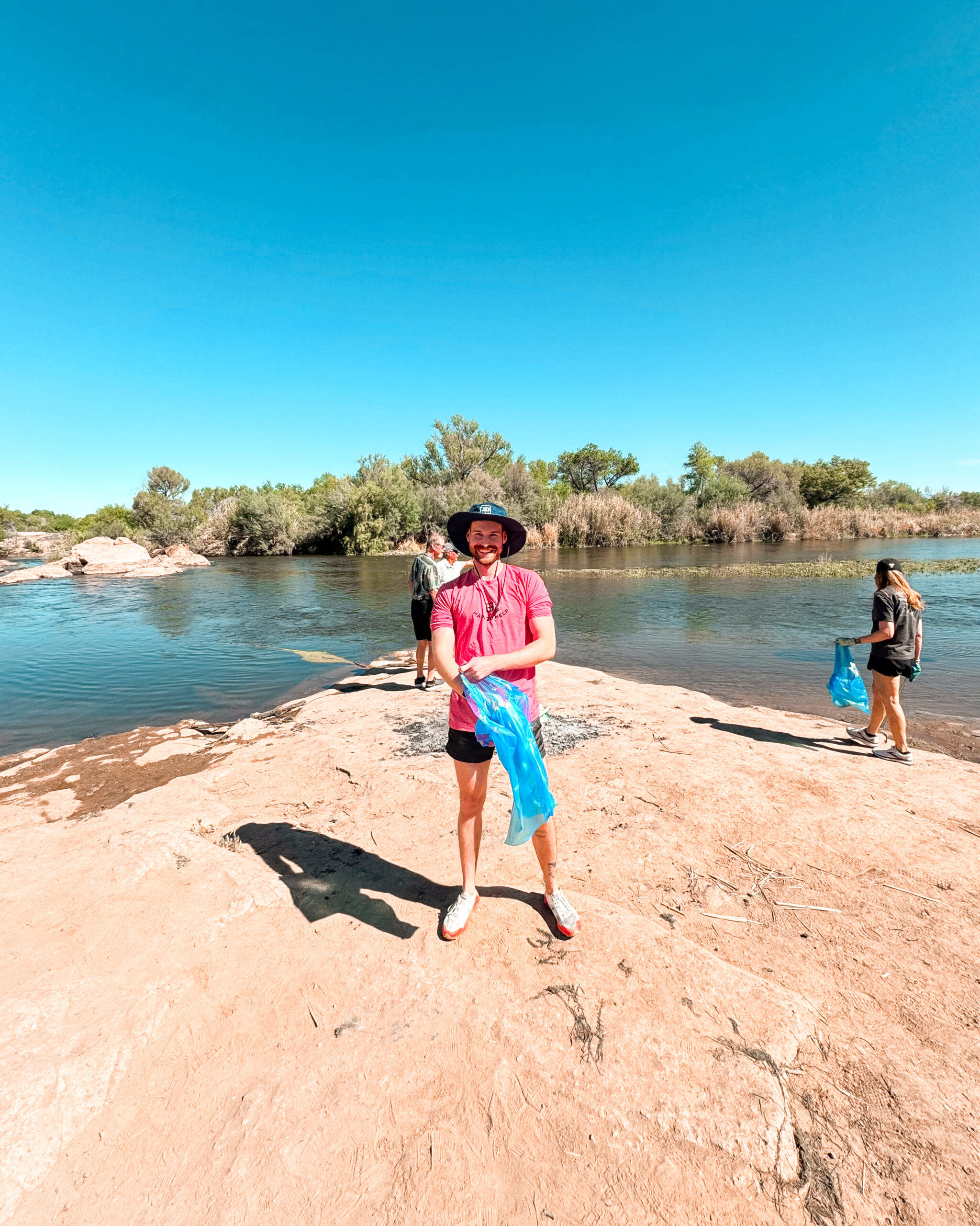 Christian of HAPI works along the riverbank picking up litter during cleanup efforts at the Salt River